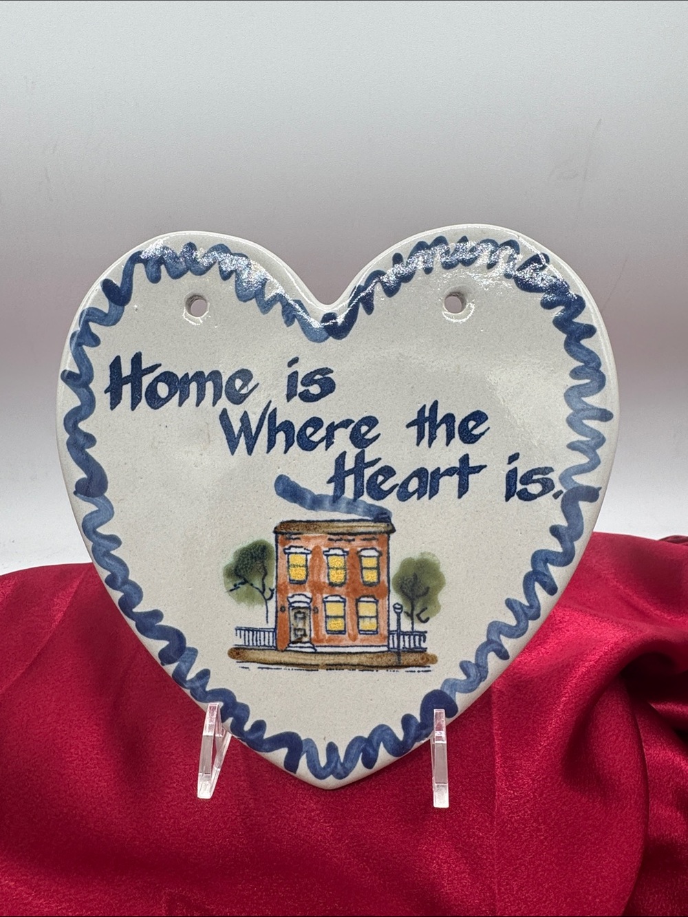 A vintage Louisville Stoneware "Home Is Where the Heart Is" Ceramic Wall Plaque